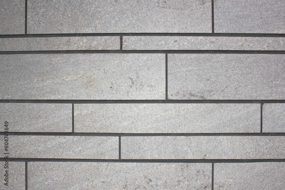 Obraz premium Facade of a building made of blocks of gray color, texture, background close-up. Blocks, stone structure of seams and blocks design.