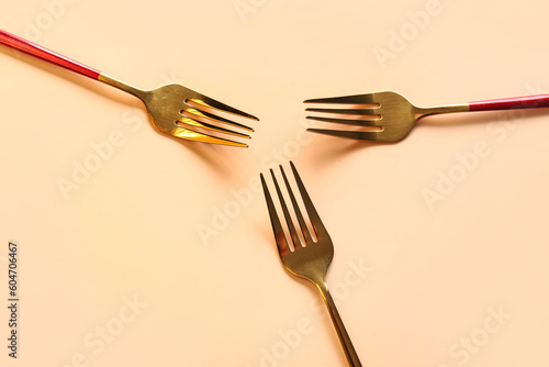 Stylish forks on beige background