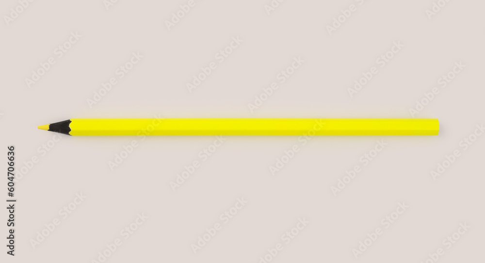 Neon yellow color pencil on light beige neutral background. Neon yellow color pencil on light beige neutral background.