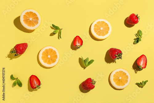 Fototapeta Naklejka Na Ścianę i Meble -  Fresh strawberries with lemon and mint on yellow background