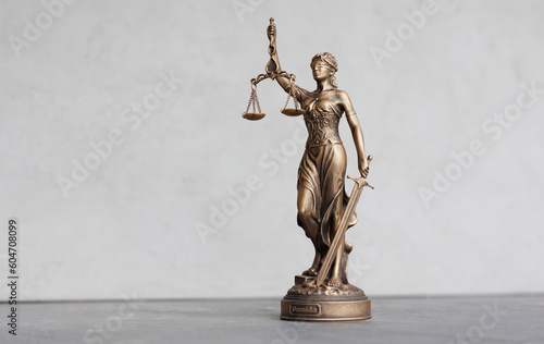 themis goddess of justice statuette on light gray background. symbol of law with scales sword in hands. legal company or university of law and judicial structure. court acquittal of the verdict
