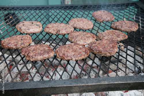 Beef burgers on a grill during a food festival