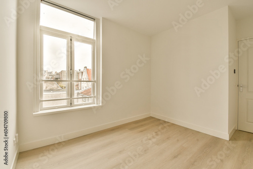 an empty room with wood floor and white walls, there is a window that looks out to the city below