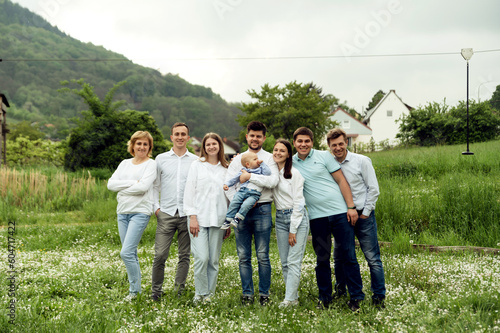 portrait of a happy big family in nature. family of three generations. a group of close people. European family. mom and dad hold son next to grandma and grandpa and siblings