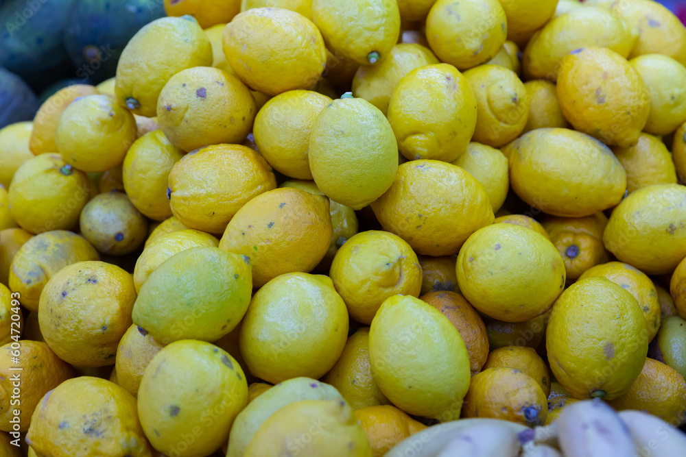Lot of yellow organic fresh lemons on shelf in the supermarket