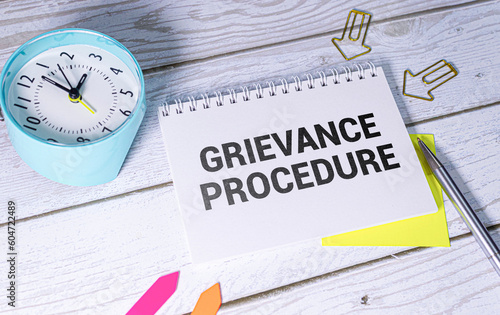 Fototapeta Text grievance procedure on notepad with office tools, pen on financial report