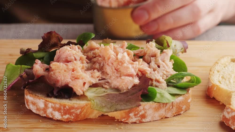 Chef cooking tuna sandwich, cook preparing a tuna eggs salad sandwich at the ingredient station of a cafe restaurant kitchen. Chef cooking tuna sandwich, cook preparing a tuna eggs salad sandwich at the ingredient station of a cafe restaurant kitchen.