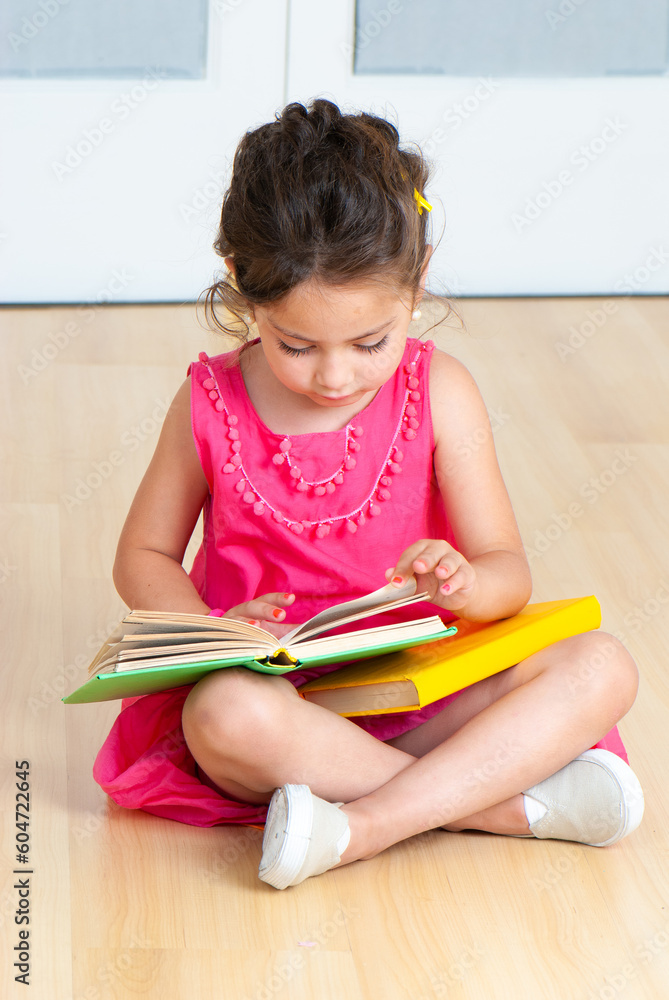 girl with books sitting on the floor in kindergarten girl with books sitting on the floor in kindergarten