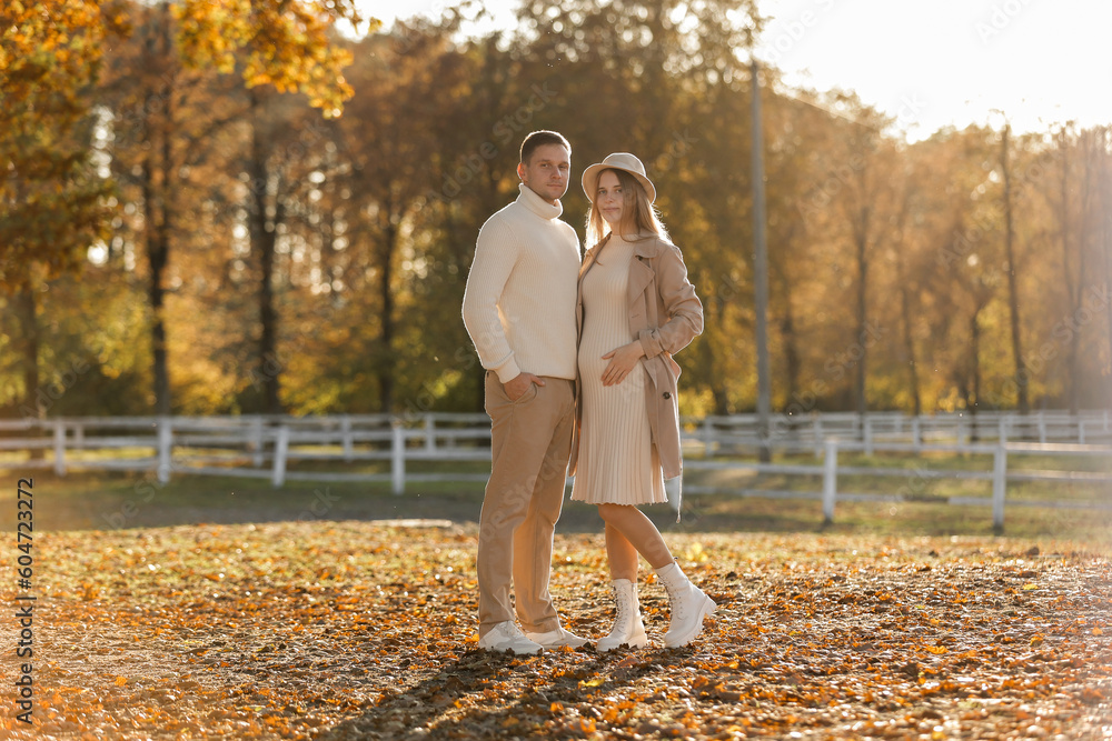 Fototapeta premium Young stylish couple lovers are hugging in the autumn park. Lovely romantic moment between man and woman in love. Happy family. Love, youth, happiness concept.