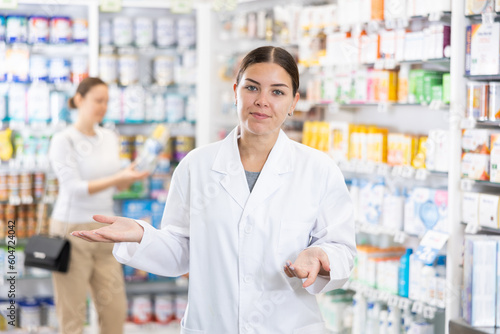 Young female pharmacist in medical uniform posing while working in pharmacy