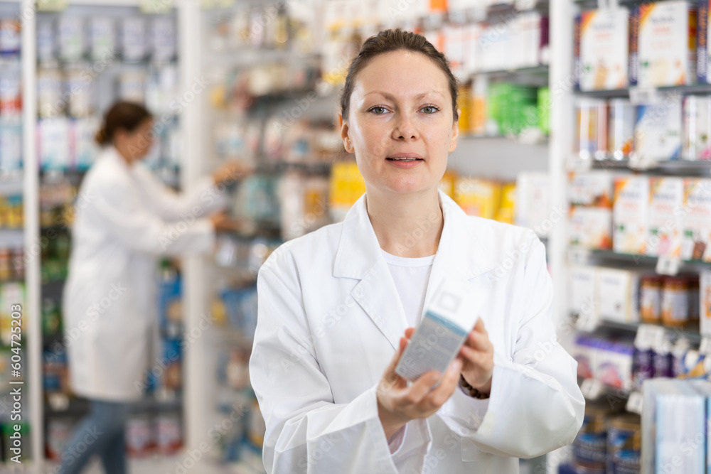 Positive female pharmacist offers various body care medicines