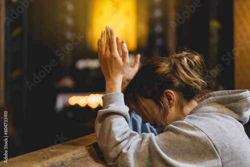 Leinwand Poster Woman praying on her knees in an ancient Catholic temple to God