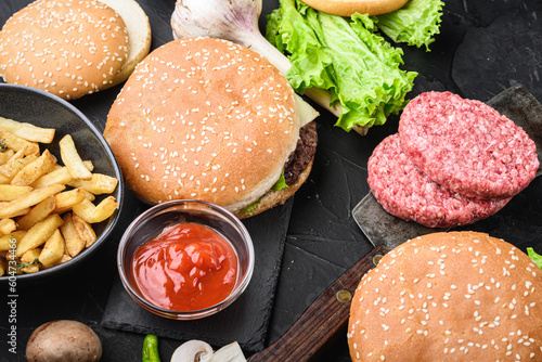Burger and groundbeef steak cutlets  on black textured background photo