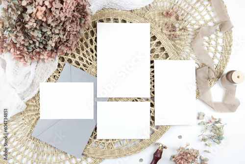 5x7 invitation, 4x6 enclosure card, rsvp half card. Wedding stationery suite mock-up styled with boho decor, dried hydrangea flowers bouquet, rattan lace mats, vintage wax seal, and silk ribbon.