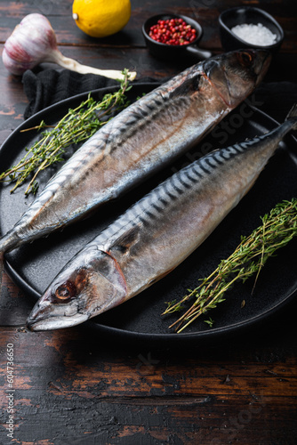 Fresh whole mackerel with ingredients on wooden table