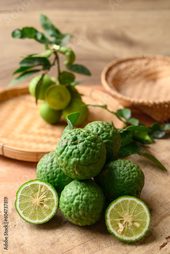 Kaffir lime and lime fruit on wooden background, Organic ingredients in Thai cuisne, beauty and cosmetics