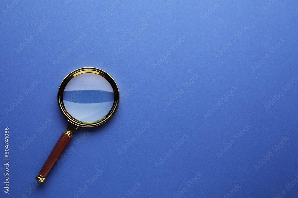 Magnifying glass on blue background, top view. Space for text Magnifying glass on blue background, top view. Space for text
