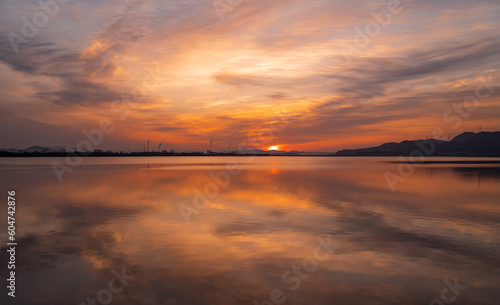 朝日の写真。手前の湖に映る雲の陰影がきれいです