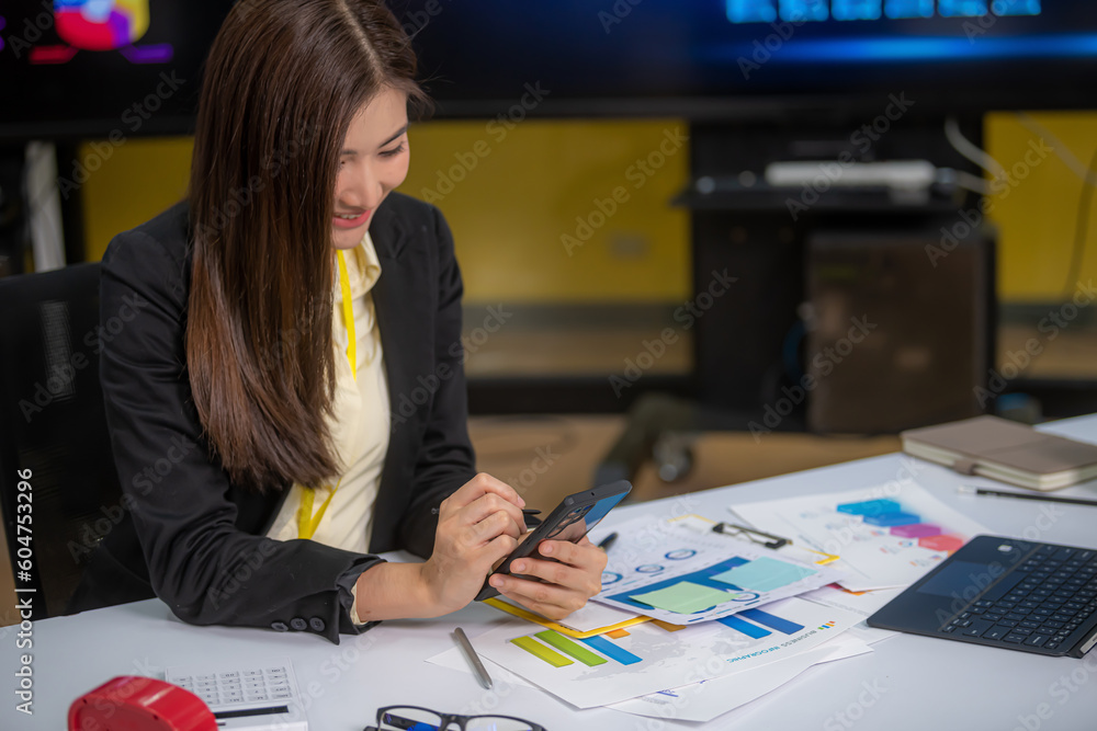 Women are happily playing the phone in the office.