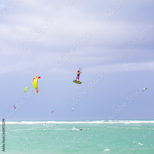 Kiteboarding. Fun in the ocean. Extreme Sport Kitesurfing. Kitesurfer jumping high in the air performing triks during kitesurfing session