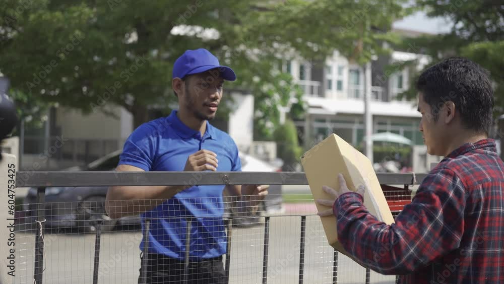 Postman delivering parcel home with smile and happy face, Asian man receiving box from postman at door, home delivery concept. 4k video. Postman delivering parcel home with smile and happy face, Asian man receiving box from postman at door, home delivery concept. 4k video.