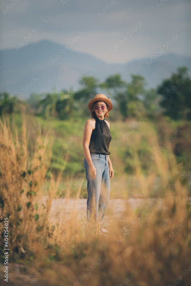 asian woman wearing straw hat standing outdoor toothy smiling with happiness face