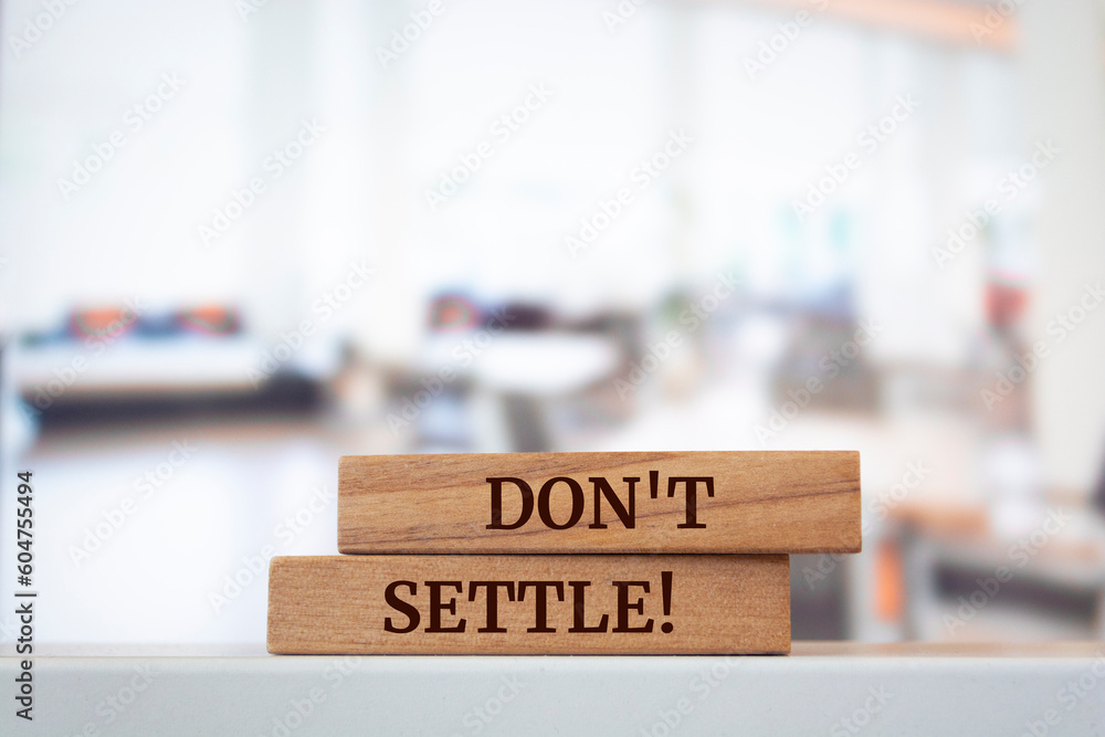 Wooden blocks with words 'Don't settle'.