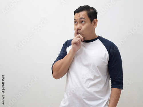 Man looking to the side with stupid thinking gesture, with finger in his nose