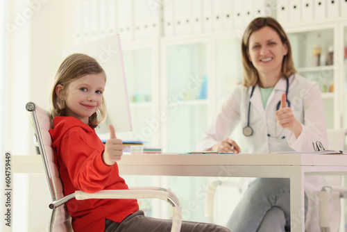 Little girl and doctor show sign of approval at appointment