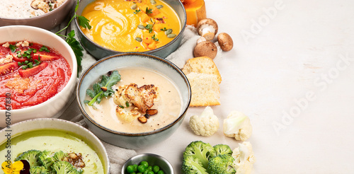 Composition with various soups, ingredients and space for text on white background. Healthy food.