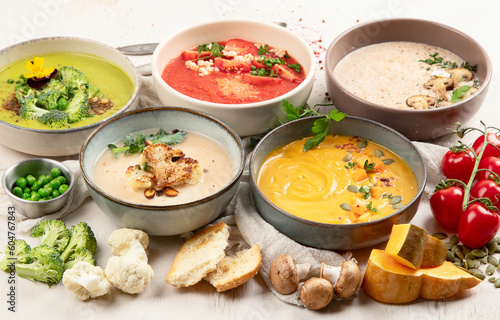 Composition with various soups, ingredients and space for text on white background. Healthy food.