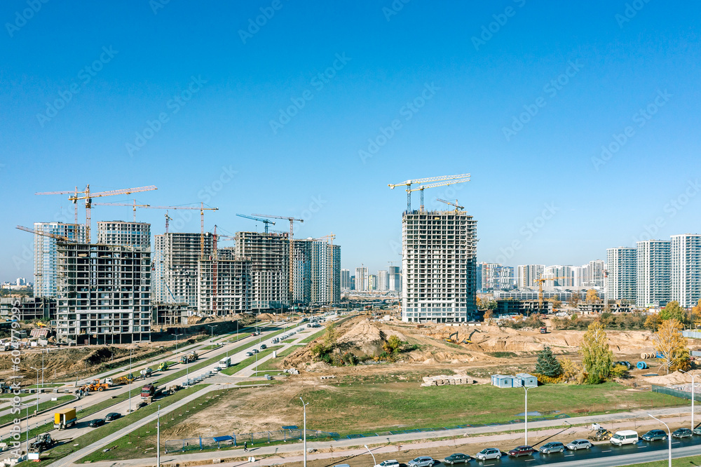 construction of new residential area. high-rise apartment buildings under construction on urban background. aerial drone view.