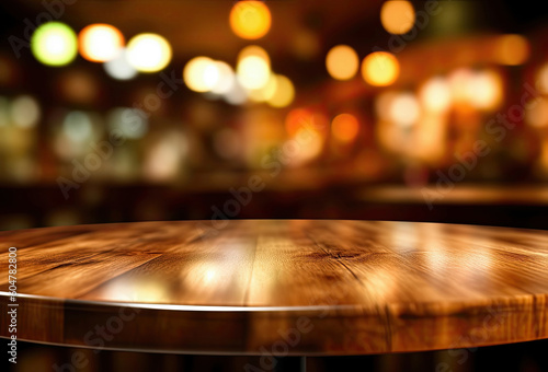 Empty wooden round table and pub or bar blur background with bokeh light.
