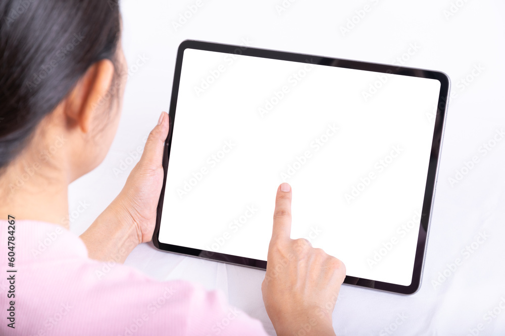 Women useing finger to touch tablet on table, tablet have white screen, rear. view from back to front of women Women useing finger to touch tablet on table, tablet have white screen, rear. view from back to front of women