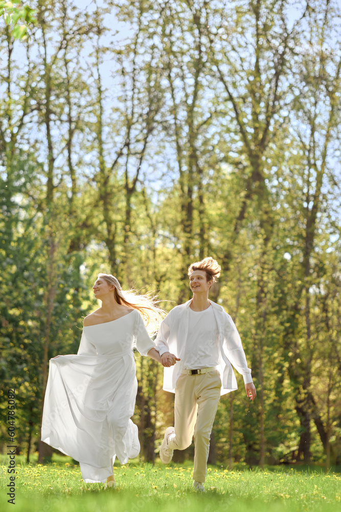 Happy newlyweds holding hands and running across the lawn Happy newlyweds holding hands and running across the lawn