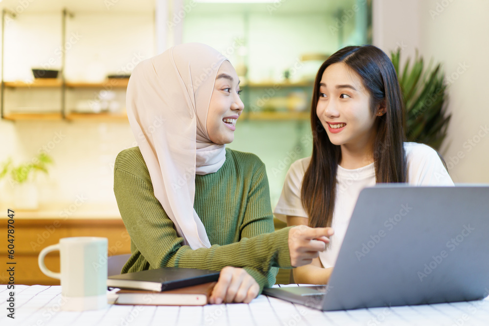 Happy cheerful Asian females university student discussing or doing a homework together in the pantry area in dormitory. Happy cheerful Asian females university student discussing or doing a homework together in the pantry area in dormitory.