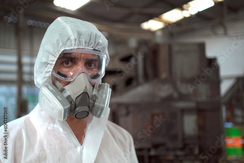 Team of scientist wearing a chemical protection suit and high efficiency filter face mask working in the bio - chemical contaminated factory.
