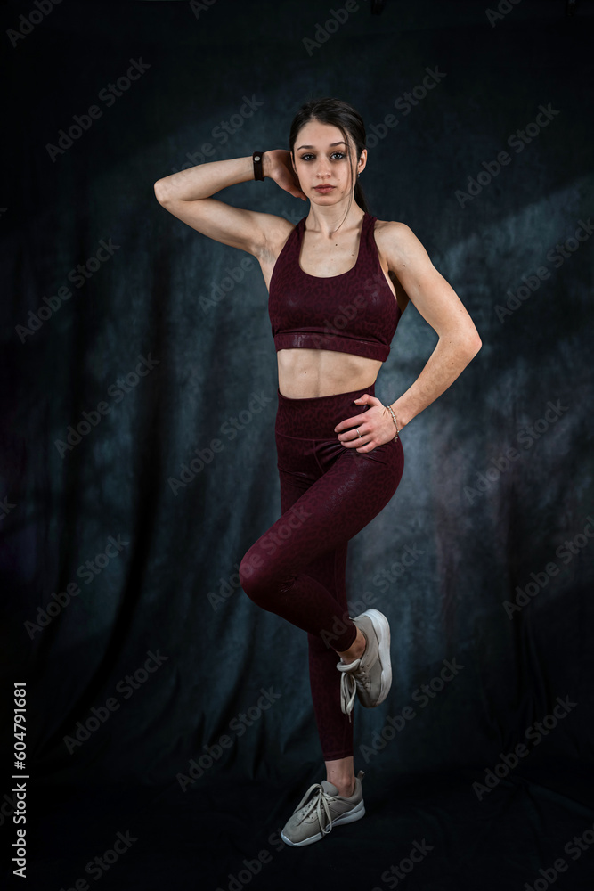 Portrait of happy beautiful fit woman in sport cloth isolated on black