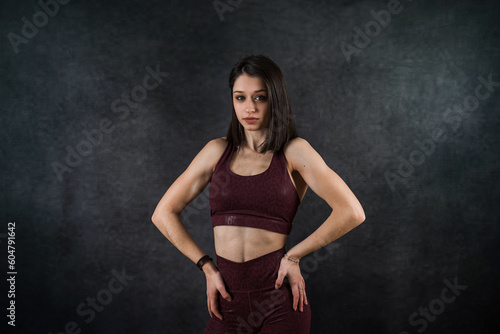 Portrait of happy beautiful fit woman in sport cloth isolated on black