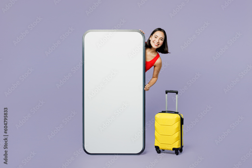 Traveler woman wears red casual clothes big huge blank screen mobile cell phone isolated on plain pastel purple background. Tourist travel in free time rest getaway. Air flight trip journey concept.