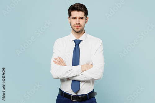 Konstfotografi Young sad frowning employee business man corporate lawyer wear classic formal shirt tie work in office look camera hold hands crossed folded isolated on plain pastel blue background studio portrait