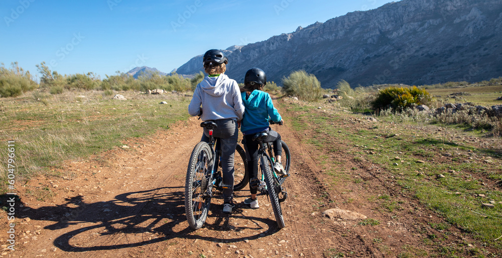 Fototapeta premium Two children in bike- Brother riding in mountain bike