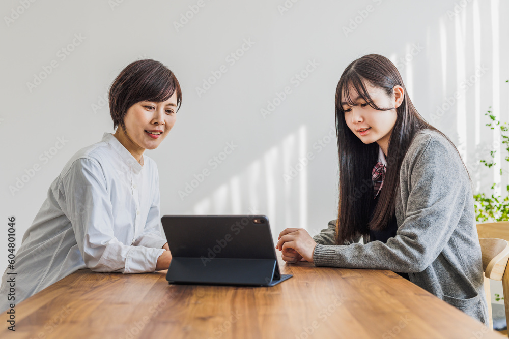 タブレットを見る日本人女性と女子学生 タブレットを見る日本人女性と女子学生