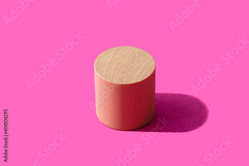 3D render of wooden cylinder against pink background photo
