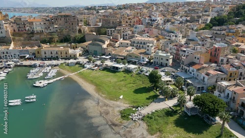 This aerial drone video shows the beautiful coastal city of Castellammare Del Golfo in Sicily, southern Italy. The city has old architecture and a marina wherefrom boats sail on the mediterranean sea. photo