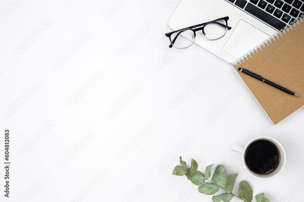 Flat lay white background with laptop, notepad, coffee cup and glasses.