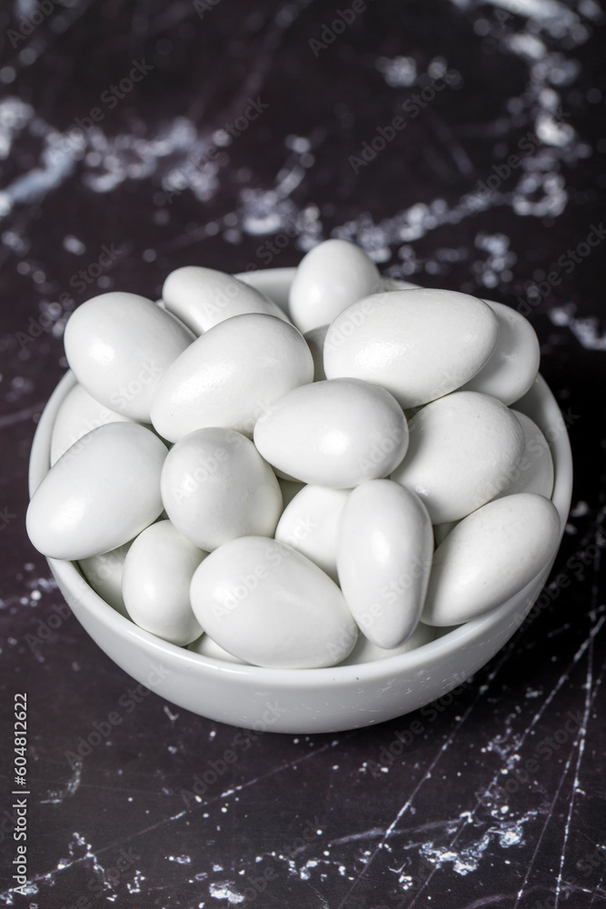 Chocolate and almond dragee. Chocolate dragee in ceramic bowl on dark background. Close up Chocolate and almond dragee. Chocolate dragee in ceramic bowl on dark background. Close up