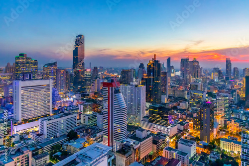 Cityscape panorama of city in twilight sunset.Beautiful blue sky with space.Business area skyscraper building.Trade center in town.Light technology form city.Yellow and orange light.Aerial view.