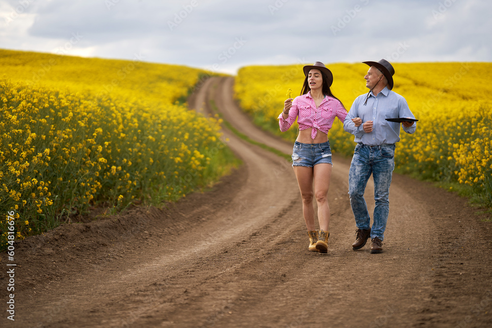 Obraz premium Farmers couple examining canola fields