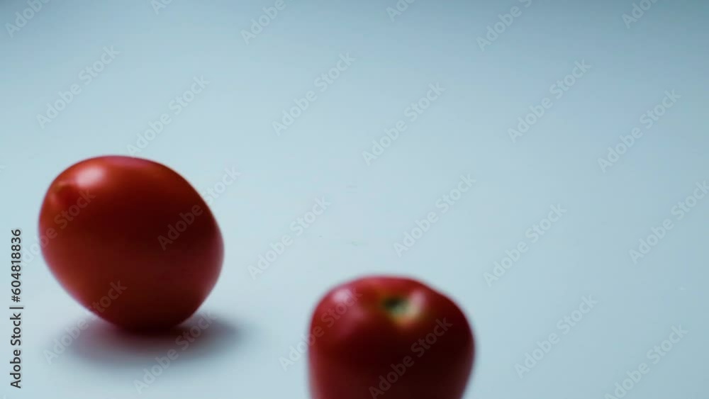 Heirloom and cherry tomato fall from above on grey backdrop, space for text Heirloom and cherry tomato fall from above on grey backdrop, space for text